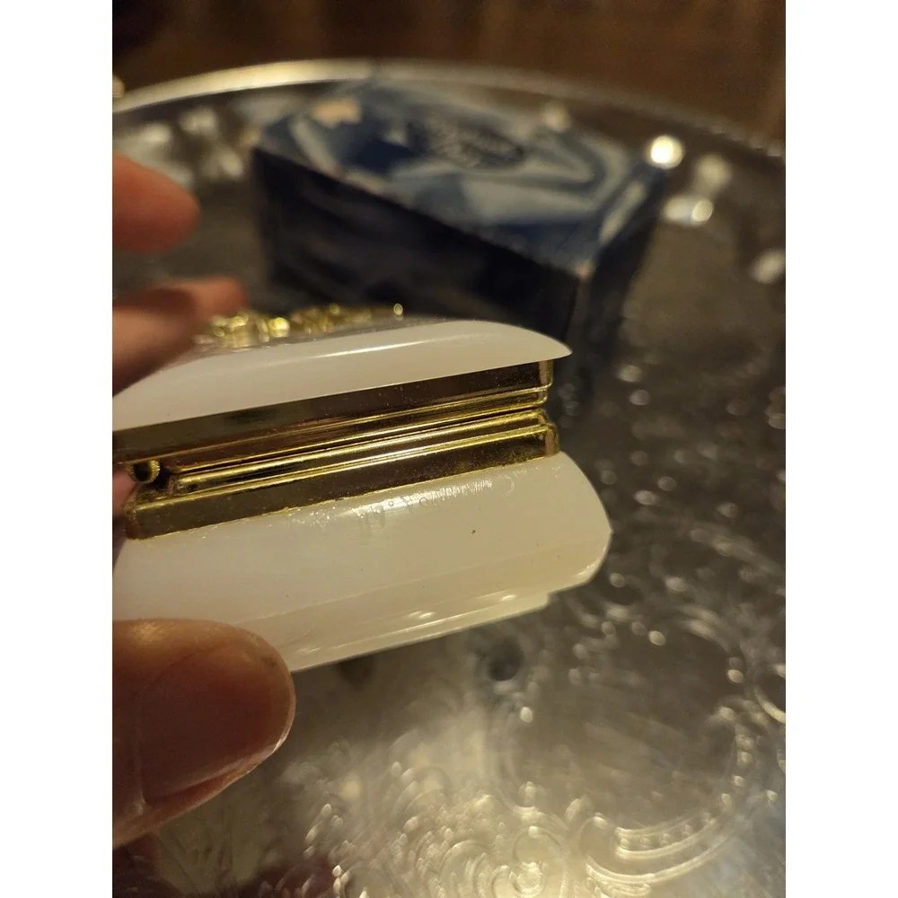 vintage white hinged trinket box features a polished finish with a delicate,...